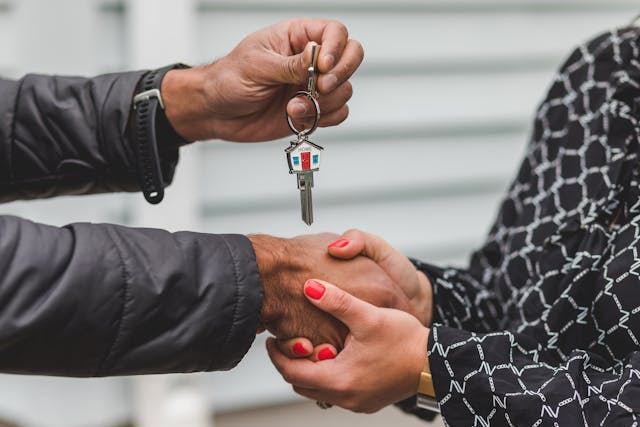 two people shaking hands an exchanging house keys